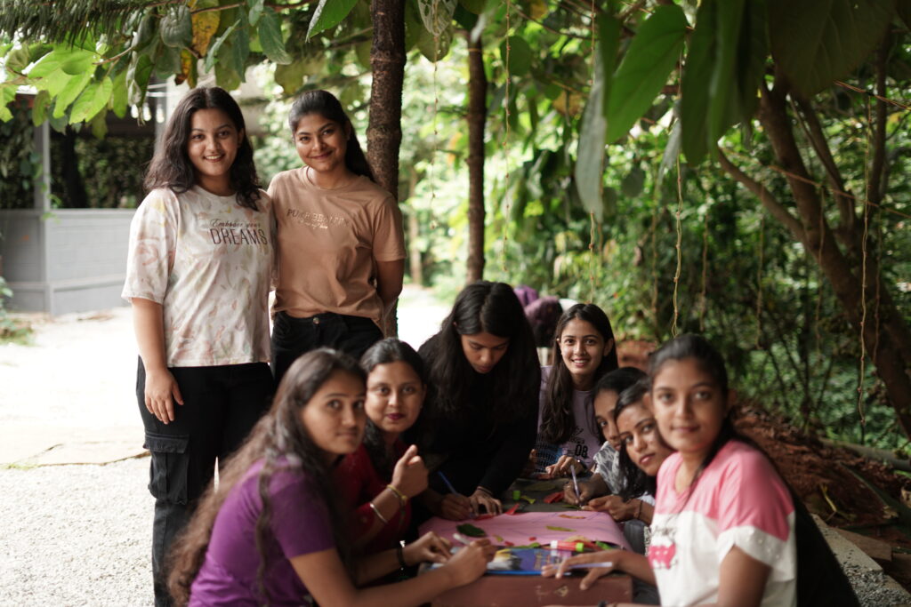 Participants wearing AEL T-shirts are actively engaged in a team-building activity in an outdoor setting. They are collaborating, communicating, and having fun as they complete the challenge together.