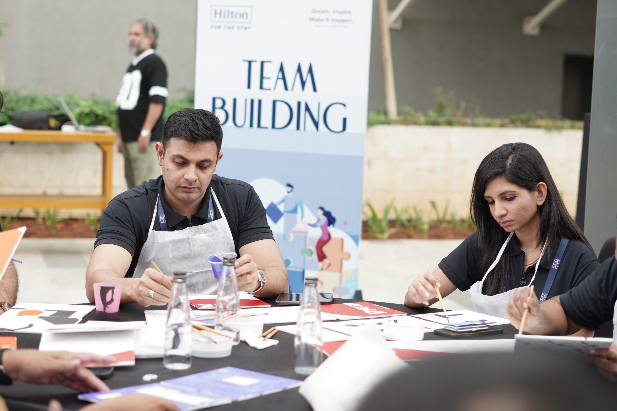 Participants contributing to a shared artwork in a collective canvas activity promoting collaboration and alignment